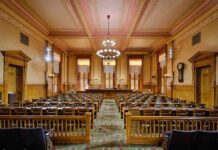 Congress Outsmarts Trump — Housing Bombshell Lands Interior view of a historic courtroom with wooden furnishings and chandeliers