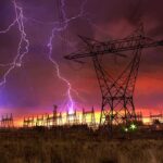 Data Center Pause Shocks Wall Street Lightning strikes illuminate a power station against a colorful sunset sky