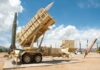 Patriot missile defense system on display outdoors with various missiles in the background