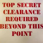 Gates’ Nuclear Clearance Bombshell Sign with red stenciled letters on a beige background