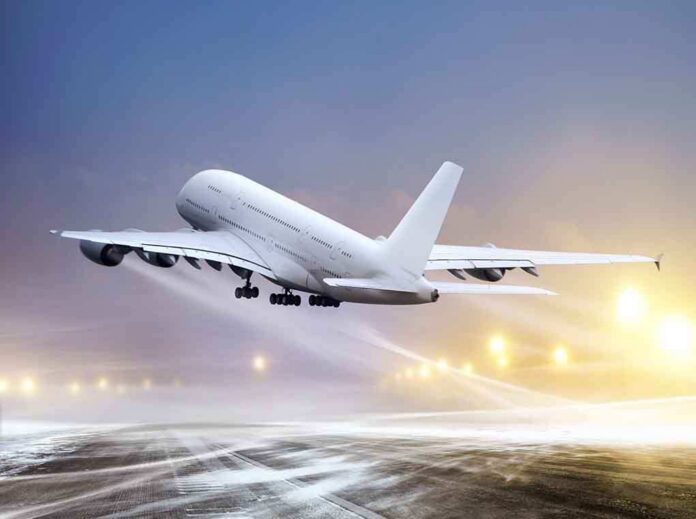 shutterstock_94244692 An airplane taking off from an airport runway against a twilight sky