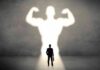 GLP-1 Shock: Lean Mass Vanishes Businessman with briefcase casts a large muscular shadow on wall