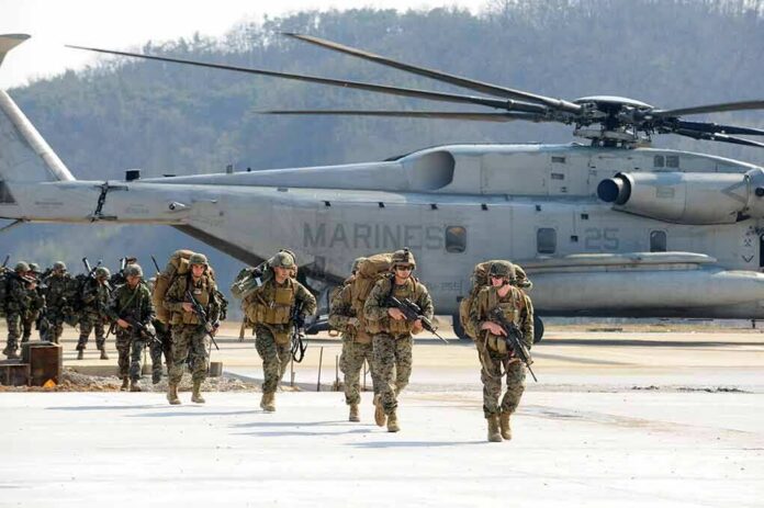 shutterstock_1123252001-1 Soldiers disembark and walk past a large military helicopter