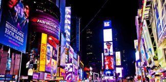 Times Square at night with bright billboards and yellow taxis