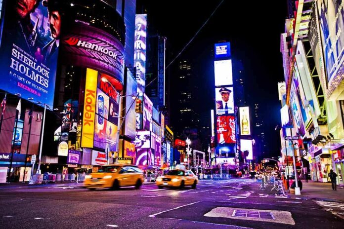 shutterstock_112751527 Times Square at night with bright billboards and yellow taxis