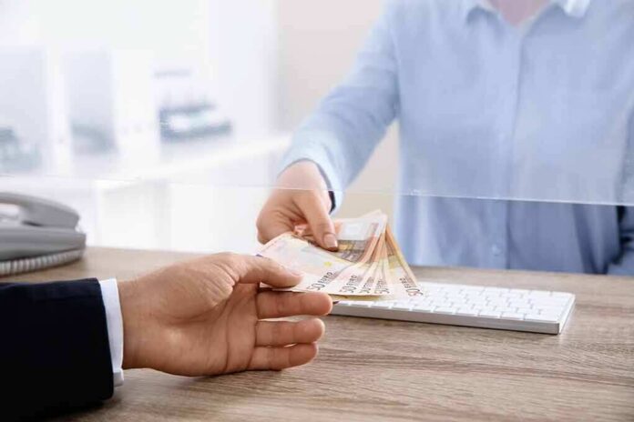 Bank teller handing euro banknotes to customer