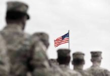$30K Bounty Put On U.S. Troops American flag above blurred soldiers in formation