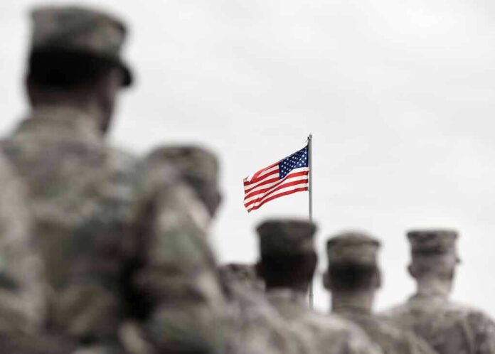 American flag above blurred soldiers in formation