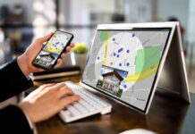 Zillow-Redfin Truce UPENDED—Game On Person using phone and laptop with real estate map app