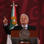 Cartel-Tied Governor Back In Power speaker at a podium gesturing with one finger raised