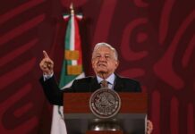 Cartel-Tied Governor Back In Power speaker at a podium gesturing with one finger raised
