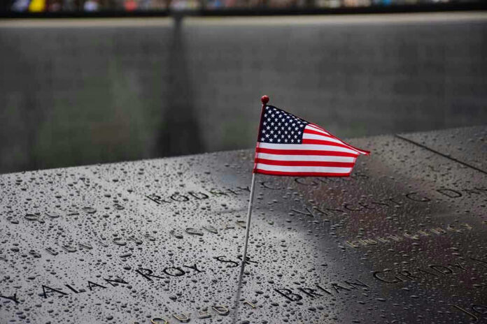 American flag on a rainy memorial nameplate.