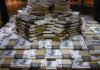 Mystery Juror Cashes In — Outrage Erupts Stacks of U.S. hundred-dollar bills arranged in a pyramid
