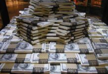 Mystery Juror Cashes In — Outrage Erupts Stacks of U.S. hundred-dollar bills arranged in a pyramid