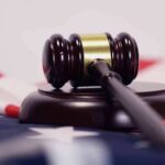 Courthouse Meltdown: Loaded Mag Hidden In Underwear? Judge’s gavel on a base over an American flag