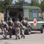 Heroic Rescue, Haunting Questions Remain Soldiers running towards a medical vehicle during a military operation