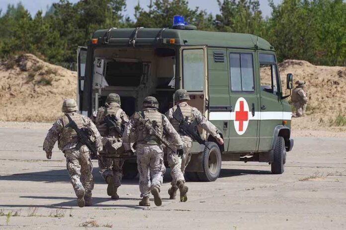 shutterstock_105071369 Soldiers running towards a medical vehicle during a military operation