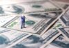Brewery Taunted Trump – Now The Bill Hits Miniature businessman standing on US dollar bills