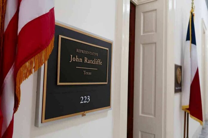 Office door with a representative name plaque and flags in a hallway