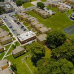 Billionaire Landlords Squeeze Rents Higher Aerial view of apartment complex with parking lots and a basketball court