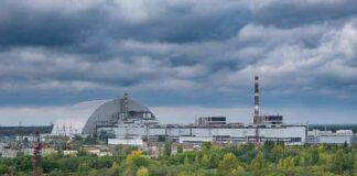 Nuclear power plant complex with domed sarcophagus and tall smokestack
