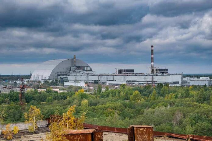 Nuclear power plant complex with domed sarcophagus and tall smokestack