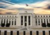 Tariff Hammer Poised — Fed On Notice Neoclassical government building with American flag at sunset