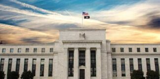 Neoclassical government building with American flag at sunset