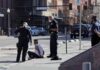 Gunfire Erupts In Downtown Tower, 3 Dead Police officers detain a seated man on a city sidewalk