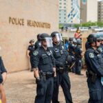 Teddy Williams and Carlos Hyde among police officers in riot gear outside police headquarters