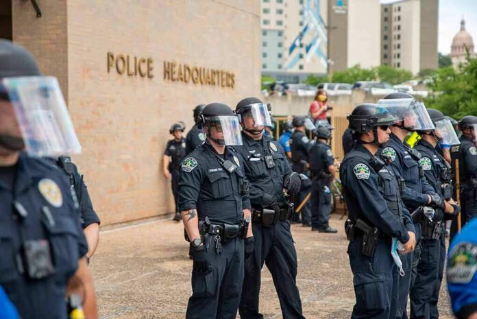 shutterstock_1747618742 Teddy Williams and Carlos Hyde among police officers in riot gear outside police headquarters