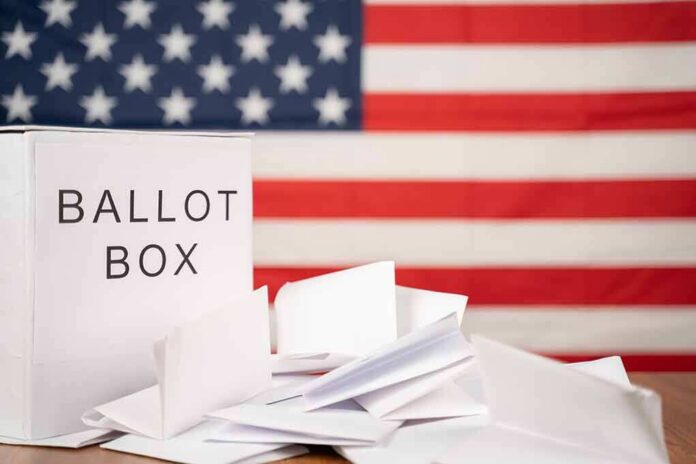 shutterstock_1818888026 Ballot box with papers in front of an American flag