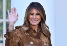 Global Kid-Safety Push – Melania’s Bold Tech Pact Melania Trump waving and smiling in a brown suede coat
