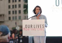 Domestic Dispute Bombshell Rattles Governor Race woman speaking at a podium during an outdoor event