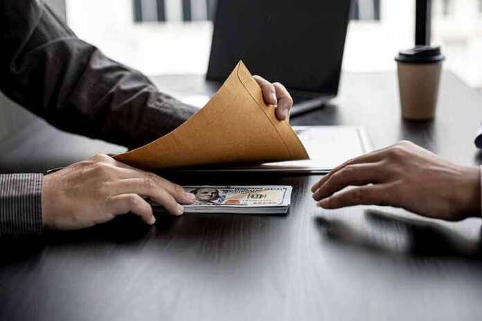 shutterstock_1925198729 Hands exchanging cash in an envelope at a desk