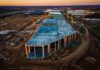 aerial view of large industrial building under construction at sunset