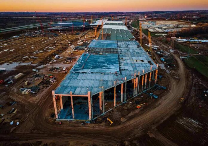 shutterstock_1934238788 aerial view of large industrial building under construction at sunset