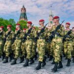 Putin’s Ballot Goes Battlefield Soldiers in camouflage uniforms march in formation with rifles