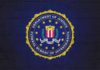 Why Another FBI Boss Just Walked FBI seal painted on a dark brick wall