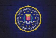 FBI seal painted on a dark brick wall