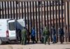 Trump: “Spain Could Be Ruined” by Mass Immigration Border agents escort a group near a tall fence and a patrol van