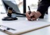 Mistrial Chaos Ignites Dr. Phil Warning Hand signing legal document beside gavel and laptop