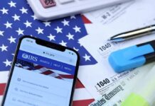 Massive IRS Windfall Hits — Now What? Smartphone showing IRS website on top of tax forms and office supplies