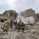 Missile Slams Defense Expo Near Kyiv Firefighters search rubble of a partially collapsed building