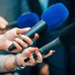 Rugby Star’s Self-Sabotage: 18-Month Ban! Reporters holding colorful microphones