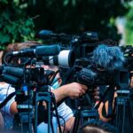 Senate Shock: Power Seat Suddenly Empty TV news cameras crowding together at an outdoor event