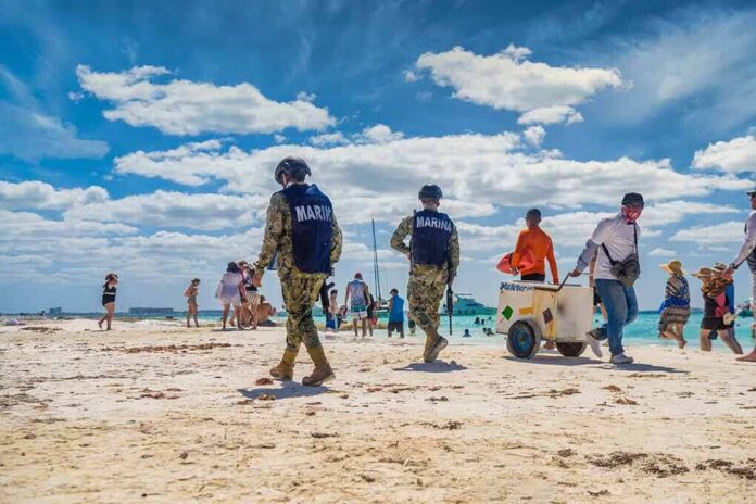 shutterstock_2228238263 Beach patrol officers walking among beachgoers on a sunny shoreline