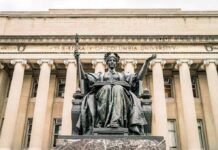Mystery Heir Claims Rock Uganda Throne Alma Mater statue before a neoclassical library facade