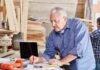 Retirement Vanishes: Work Til 70? Carpenter marking measurements on plans at a workbench