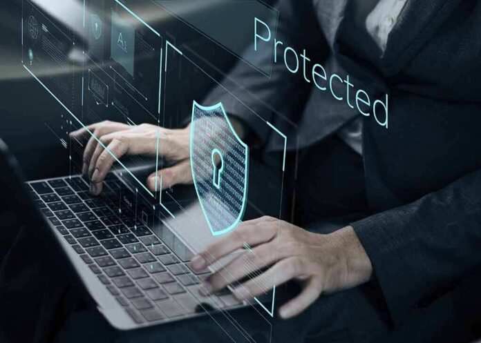 shutterstock_600760271 Person typing on laptop with digital security shield overlay